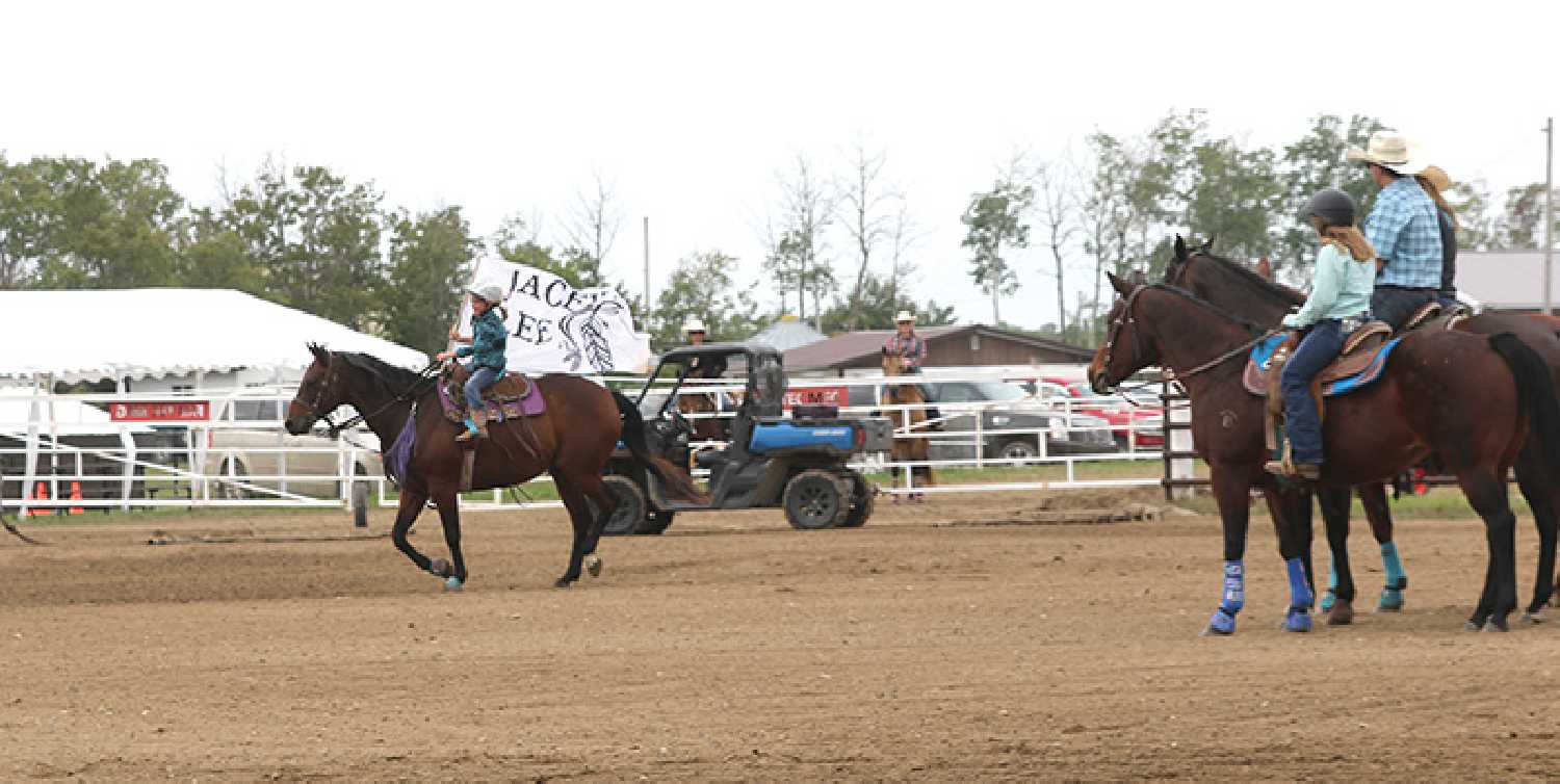 One of the kids participating in the 2023 Jacey Lee Memorial Barrel Racing event holding a flag in memory of Jacey Lee.  Photo by: Sunnette Kamffer.